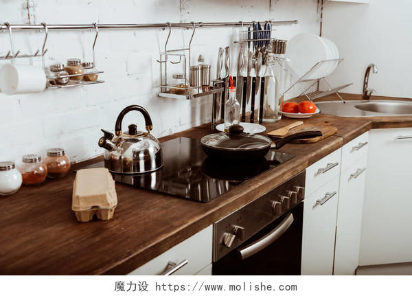现代化的厨房内饰,炉灶上有煎锅和茶壶